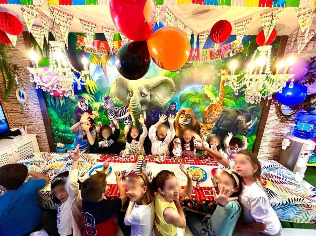 niños sentados alrededor de una mesa en un cumpleaños